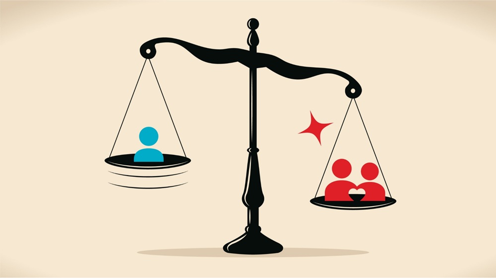 Cán cân thiên về cuộc sống gia đình với biểu tượng cặp đôi trái tim, đối lập với người độc thân một mình
